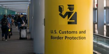 ستون زرد رنگ در فرودگاه با علامت و نوشته «حفاظت از مرز و گمرک ایالات متحده» (U.S. Customs and Border Protection).