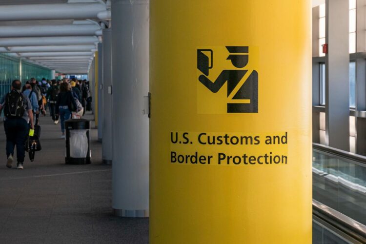 ستون زرد رنگ در فرودگاه با علامت و نوشته «حفاظت از مرز و گمرک ایالات متحده» (U.S. Customs and Border Protection).
