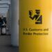 ستون زرد رنگ در فرودگاه با علامت و نوشته «حفاظت از مرز و گمرک ایالات متحده» (U.S. Customs and Border Protection).