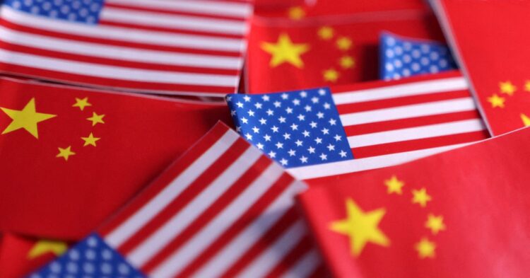 نمای نزدیک از تعداد زیادی پرچم‌های کوچک کاغذی ایالات متحده و چین که در کنار هم قرار گرفته‌اند.