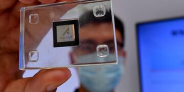 تصویری از نزدیک که یک تراشه هوش مصنوعی Ascend (متعلق به هواوی) را در قاب شیشهای در دست یک فرد نشان میدهد.