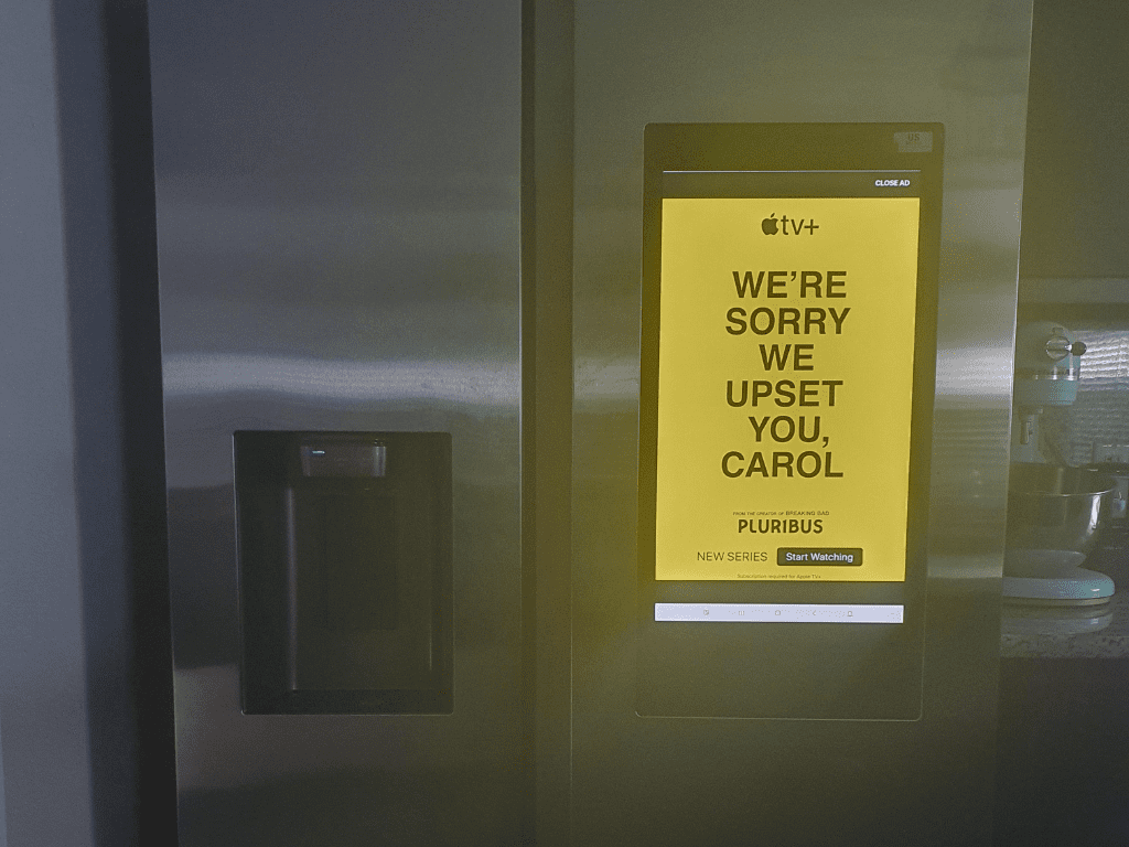 صفحه نمایش روی درب یخچال که یک پیام تبلیغاتی زردرنگ (عذرخواهی) را نشان میدهد.