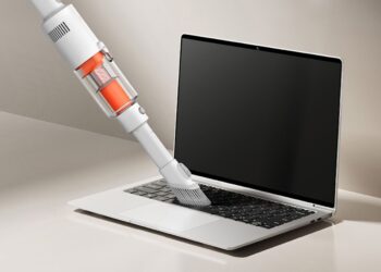 استفاده از جاروبرقی سبک و دستی شیائومی برای تمیز کردن گرد و غبار کیبورد لپ‌تاپ.