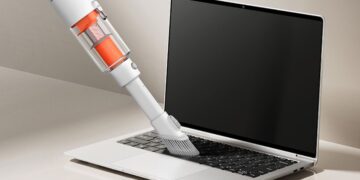 استفاده از جاروبرقی سبک و دستی شیائومی برای تمیز کردن گرد و غبار کیبورد لپتاپ.