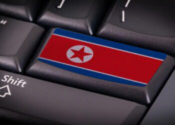 نمای کلوزآپ از صفحه‌کلید رایانه با کلیدی حاوی پرچم کره شمالی، نماد مفهومی از تهدیدات سایبری، هک و فعالیت‌ های دیجیتال منتسب به پیونگ‌یانگ