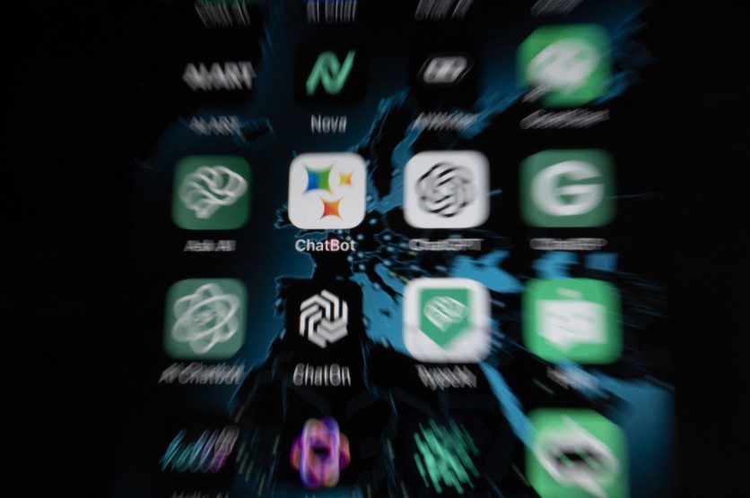 نمای نزدیک و کمی تار از صفحه نمایش گوشی هوشمند که آیکون‌های متعددی از برنامه‌های هوش مصنوعی و ربات چت، از جمله ChatGPT و Gemini را نشان می‌دهد.