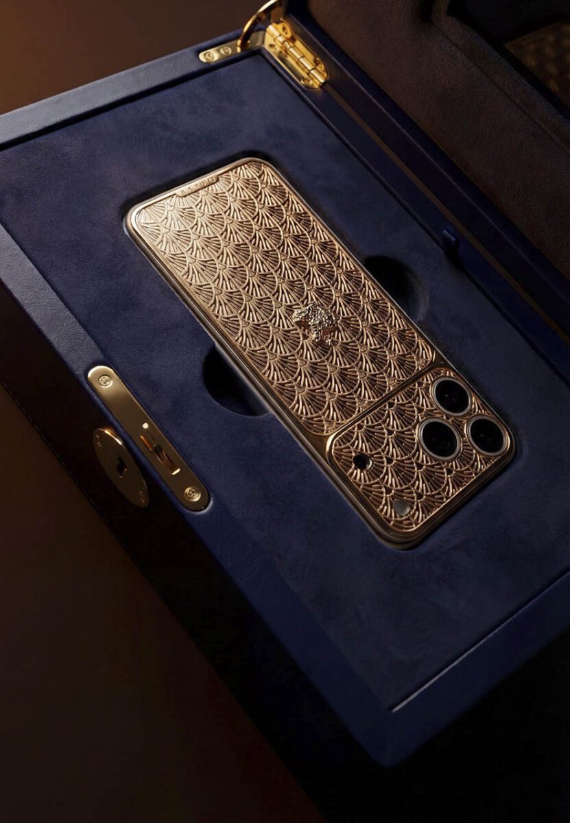 گوشی هوشمند طلایی سفارشی کاویار با نقش‌ونگار برجسته که درون جعبه مخملی آبی‌رنگ قرار گرفته است