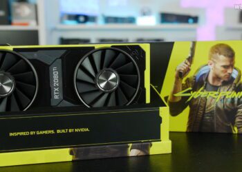 کارت گرافیک اختصاصی NVIDIA RTX 2080 Ti نسخه Cyberpunk 2077 با طراحی زرد و مشکی، قرارگرفته روی پایه نمایش در کنار جعبه بزرگ بازی