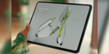 شخصی که تبلت وانپلاس را با تصویر پسزمینه انتزاعی در دست گرفته است.