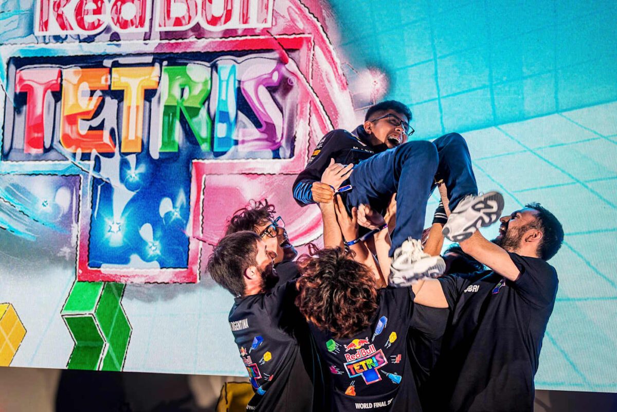 لحظه جشن پیروزی تیم Red Bull Tetris پس از صعود در مرحله نیمهنهایی فینال جهانی، در برابر پسزمینه صحنه رسمی مسابقات تتریس
