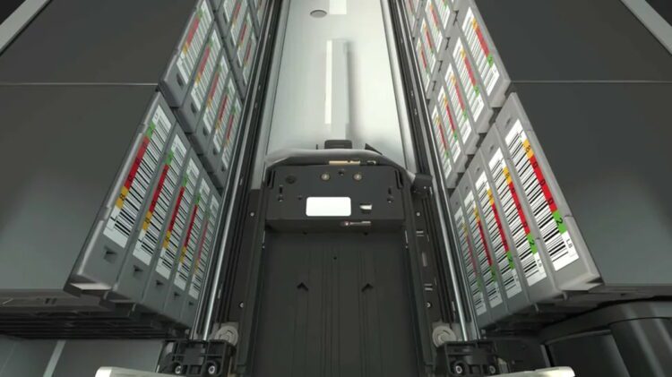 نمای داخلی یک دیتاسنتر مدرن با رکهای سرور آرایشیافته، یونیتهای ذخیرهسازی ماژولار و برچسبهای رنگی برای مدیریت و مانیتورینگ تجهیزات شبکه