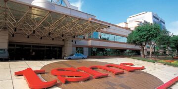 نمای بیرونی ساختمان و تابلوی قرمز رنگ شرکت تراشه‌سازی TSMC.