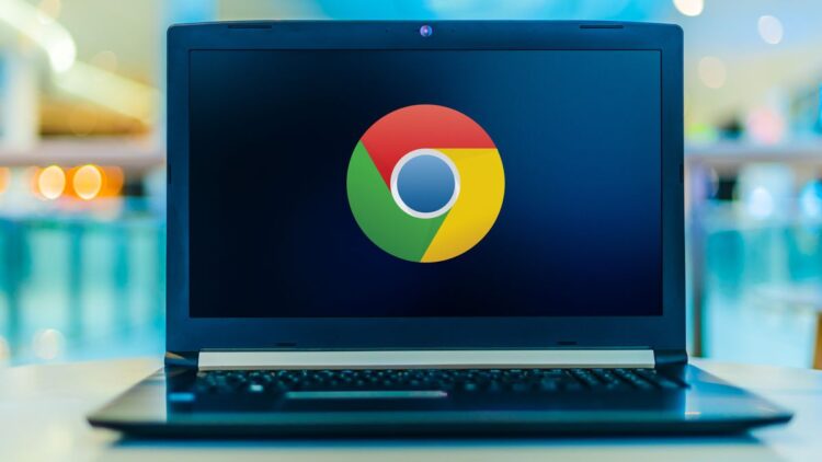 نمای لپتاپ باز با نمایش لوگوی Google Chrome در مرکز صفحهنمایش؛ دستگاه روی سطح صاف قرار دارد و پسزمینه با افکت محو رنگی، تمرکز بصری را بر برند مرورگر و استفاده دسکتاپی آن نشان میدهد.