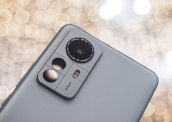 نمای نزدیک از پنل پشتی یک گوشی هوشمند خاکستری رنگ (احتمالاً سری شیائومی ۱۲) که ماژول دوربین سه‌گانه و عبارت 50MP روی آن دیده می‌شود.