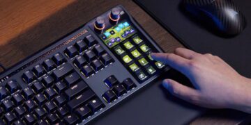 نمای محیطی از کیبورد مکانیکی Corsair Galleon 100 SD روی میز کار، نمایش کلیدهای RGB، پنل Stream Deck یکپارچه با کلیدهای LCD قابل برنامه‌ریزی و تعامل کاربر با یکی از کلیدهای ماکرو در کنار ماوس