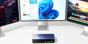 مینی پیسی روی میز کار متصل به سه مانیور که محیط ویندوز ۱۱ را نمایش میدهند.