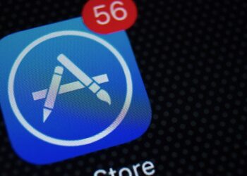 نمای نزدیک از آیکون برنامه اپ استور (App Store) بر روی صفحه نمایش موبایل با یک اعلان قرمز عدد ۵۶.