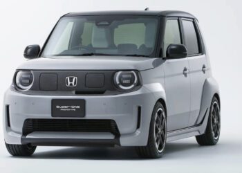 نمای سه‌رخ جلو خودروی برقی هوندا سوپر-وان ۲۰۲۶ با بدنهٔ خاکستری، طراحی جعبه‌ای، چراغ‌های گرد LED و رینگ‌های اسپرت مشکی در پس‌زمینهٔ استودیویی سفید