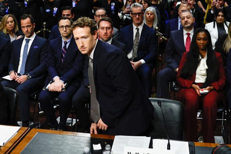 مارک زاکربرگ با کت‌وشلوار در حال بلند شدن از صندلی در یک جلسه استماع قانونی.