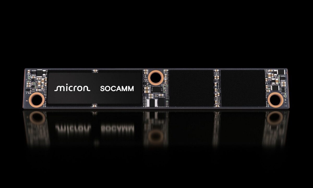 نمای استودیویی از ماژول حافظه Micron SOCAMM با فرم‌فکتور باریک، برد مدار چاپی مشکی، چیپ‌های حافظه یکپارچه، نقاط اتصال فلزی و سوراخ‌های نصب؛ پس‌زمینه کاملاً مشکی با بازتاب سطحی.