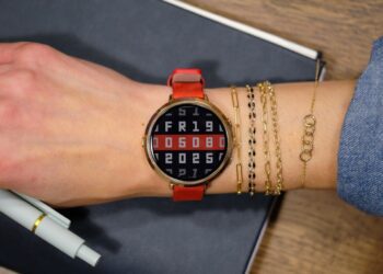 نمای نزدیک از ساعت Pebble Round 2 با بدنه نقره‌ای و بند چرمی قهوه‌ای که زمان و وضعیت آب‌وهوا را نمایش می‌دهد.