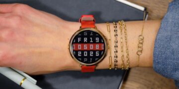 نمای نزدیک از ساعت Pebble Round 2 با بدنه نقره‌ای و بند چرمی قهوه‌ای که زمان و وضعیت آب‌وهوا را نمایش می‌دهد.