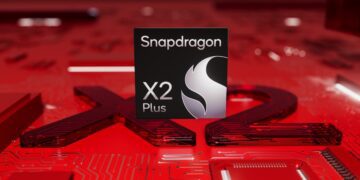 نمای نزدیک از لوگوی پردازنده Qualcomm Snapdragon X2 Plus بر روی یک مدار چاپی قرمز رنگ.