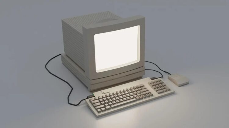 کامپیوتر قدیمی اپل شامل مانیتور CRT، کیبورد و ماوس کلاسیک روی سطح سفید.