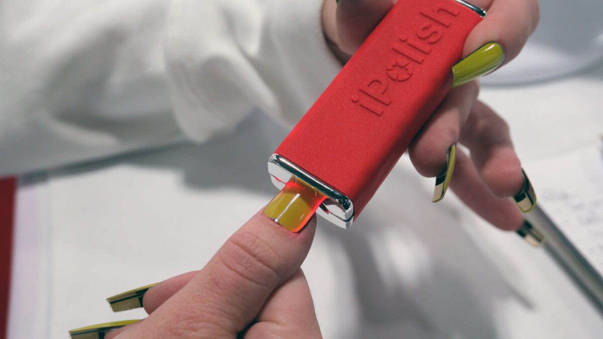 دستگاه iPolish در حال چاپ طرح و رنگ زرد بر روی ناخن به صورت خودکار و دیجیتال.