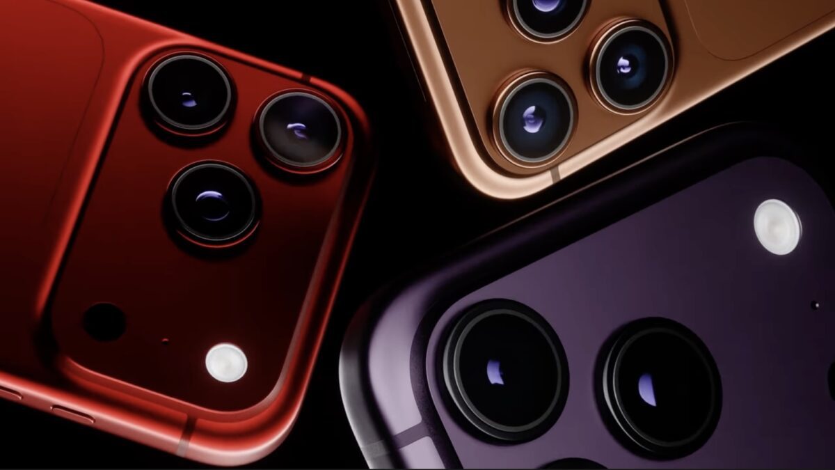 نمای نزدیک از ماژول‌های دوربین پشتی چند گوشی iPhone با طراحی مربعی و چینش سه‌گانه لنز، حلقه‌های فلزی برجسته و فلش LED؛ بدنه‌ها در رنگ‌های متالیک متنوع شامل قرمز، طلایی و بنفش روی پس‌زمینه تیره به‌صورت ترکیب‌بندی مورب نمایش داده شده‌اند.