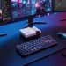 نمای یک میز کار با کیبورد مکانیکی و مینی پیسی Acemagic Retro X5 با طراحی کلاسیک شبیه به کنسولهای قدیمی در مرکز میز.