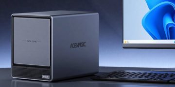 نمای یک مینی‌پی‌سی Acemagic N3A با طراحی مکعبی و بدنه فلزی خاکستری که روی میز قرار گرفته است. در کنار دستگاه، یک نمایشگر دسکتاپ با رابط کاربری Windows 11 و صفحه‌کلید دیده می‌شود. پنل جلویی دستگاه دارای دریچه تهویه و برچسب N3A است و روی بدنه لوگوی ACEMAGIC حک شده. تصویر بر کاربرد کامپیوتر رومیزی جمع‌وجور، پردازش روزمره و استفاده حرفه‌ای تمرکز دارد.