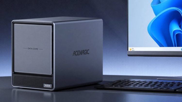 نمای یک مینی‌پی‌سی Acemagic N3A با طراحی مکعبی و بدنه فلزی خاکستری که روی میز قرار گرفته است. در کنار دستگاه، یک نمایشگر دسکتاپ با رابط کاربری Windows 11 و صفحه‌کلید دیده می‌شود. پنل جلویی دستگاه دارای دریچه تهویه و برچسب N3A است و روی بدنه لوگوی ACEMAGIC حک شده. تصویر بر کاربرد کامپیوتر رومیزی جمع‌وجور، پردازش روزمره و استفاده حرفه‌ای تمرکز دارد.