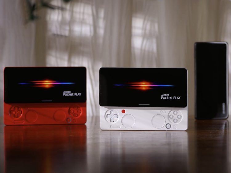 دو کنسول بازی دستی Ayaneo Pocket Play در رنگ‌های قرمز و سفید روی میز.