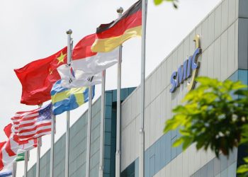 نمای بیرونی ساختمان شرکت SMIC با ردیفی از پرچم کشورهای مختلف در حال اهتزاز.