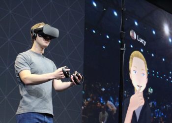 مارک زاکربرگ در حال استفاده از هدست واقعیت مجازی و کنترلرها در یک کنفرانس.