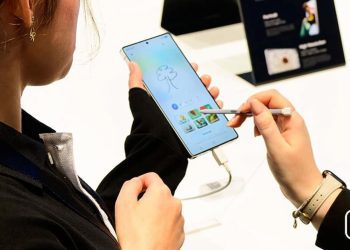 کاربری که در حال استفاده از قلم S-Pen روی صفحه‌نمایش یک گوشی هوشمند (احتمالاً گلکسی S25) است.