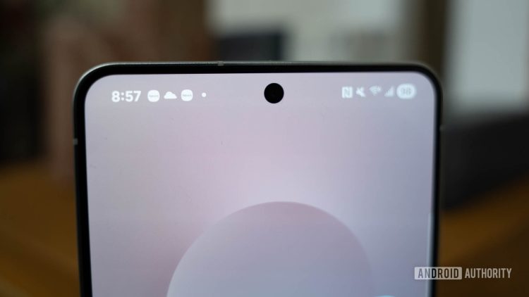 «نمای نزدیک از بخش بالای صفحه نمایش یک گوشی هوشمند که دوربین سلفی حفره‌ای (Punch-hole) را نشان می‌دهد.»