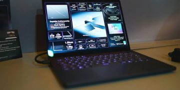 نمای یک لپ‌تاپ مدرن با نمایشگر روشن که صفحه‌ای گرافیکی شامل مشخصات فنی و ویژگی‌های کلیدی دستگاه را نمایش می‌دهد. اطلاعاتی مانند طراحی بدنه، نورپردازی، توان پردازشی، نمایشگر OLED و قابلیت‌های گرافیکی به‌صورت کارت‌های تصویری روی صفحه دیده می‌شوند. کیبورد با نور پس‌زمینه و طراحی باریک دستگاه، تمرکز تصویر را بر لپ‌تاپ‌های قدرتمند و رده‌بالا نشان می‌دهد.