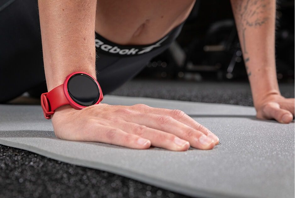 شخصی در حال انجام حرکت شنا (Push-up) در حالی که ساعت هوشمند ریباک راش به مچ دارد.