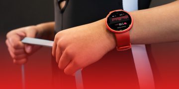 نمای نزدیک از ساعت هوشمند ریباک راش قرمز رنگ روی مچ دست در حال نمایش ضربان قلب.