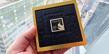 یک ماژول پردازنده Snapdragon X2 Elite با حاشیه طلایی که در دست گرفته شده است.