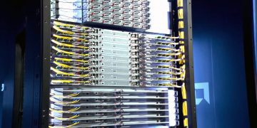 نمای داخلی یک رک سرور پیشرفته با کابلکشیهای منظم زرد رنگ برای زیرساخت AI.