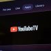 نمای نزدیک از صفحه تلویزیون که اپلیکیشن YouTube TV را در بخش برنامه‌ها (Apps) نشان می‌دهد.