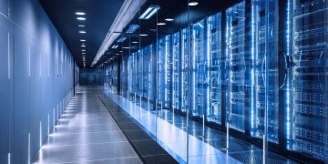 راهروی یک مرکز داده مدرن با ردیفهای سرور مجهز به نور آبی که زیرساخت پردازشی هوش مصنوعی را در محیطی کنترلشده نشان میدهد.