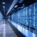 راهروی یک مرکز داده مدرن با ردیفهای سرور مجهز به نور آبی که زیرساخت پردازشی هوش مصنوعی را در محیطی کنترلشده نشان میدهد.