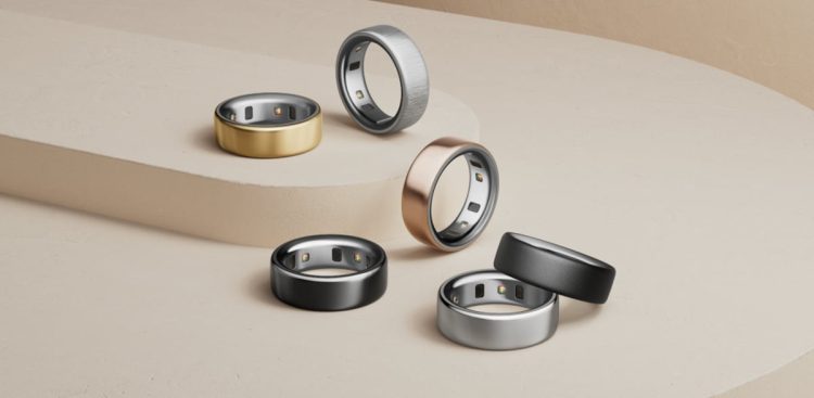 نمای استودیویی از چند مدل Oura Ring 4 در رنگ‌های مشکی، نقره‌ای، طلایی و برنزی روی سطح پله‌ای؛ تمرکز بر طراحی لوکس، سنسورهای داخلی و کاربرد حلقه هوشمند در پایش خواب و سلامت