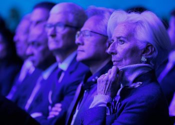 حاضران تیم کوک، جنسن هواهنگ و غیره در یک رویداد رسمی یا کنفرانس با نورپردازی آبی و بنفش، نشسته در ردیف‌های سالن و در حال گوش دادن به سخنرانی یا ارائه