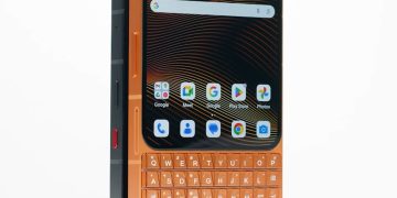 تصویر تبلیغاتی از گوشی Unihertz Titan 2 Elite در نمای سهربع، با بدنه دو رنگ مشکی و نارنجی. کیبورد فیزیکی QWERTY همرنگ بدنه نارنجی طراحی شده و کلیدهای کناری قابلمشاهده هستند. این تصویر بر تنوع رنگ، طراحی مقاوم و تمرکز دستگاه بر کاربری حرفهای و تایپ دقیق تأکید دارد.