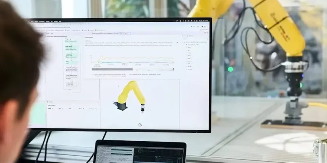 یک بازوی ربات زرد در حال تست در آزمایشگاه و نمایش حرکات آن روی مانیتور کامپیوتر